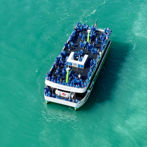 Eine Luftaufnahme des Bootes Maid of the Mist, das durch das türkisfarbene Wasser in der Nähe der Niagarafälle kreuzt.